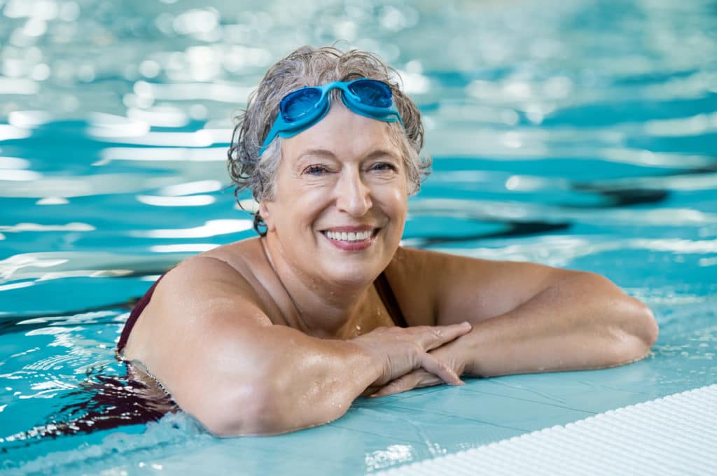 Eine ältere Dame beim Schwimmen im Hallenbad