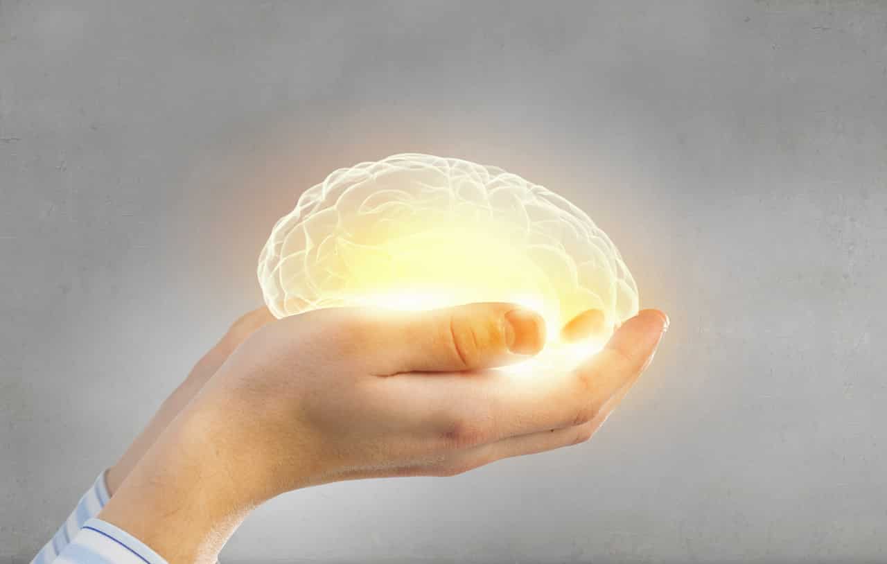 Jemand hält ein leuchtendes Gehirn in den Händen. Es ist ein Symbol für die Gesundheit des Gehirns und mögliche Demenzformen