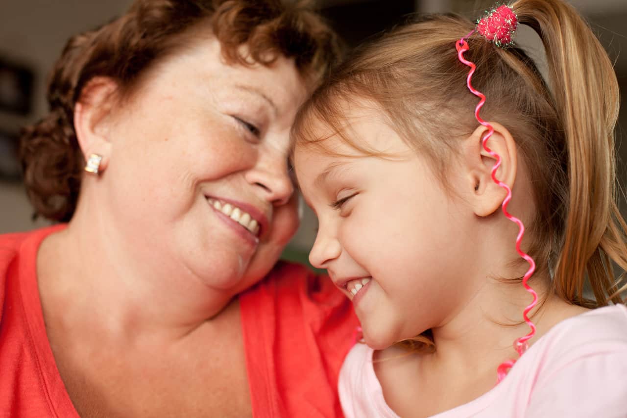 Wie kann man Demenz vorbeugen? Eine ältere Frau ist mit einem Kind zu sehen, beide sind glücklich