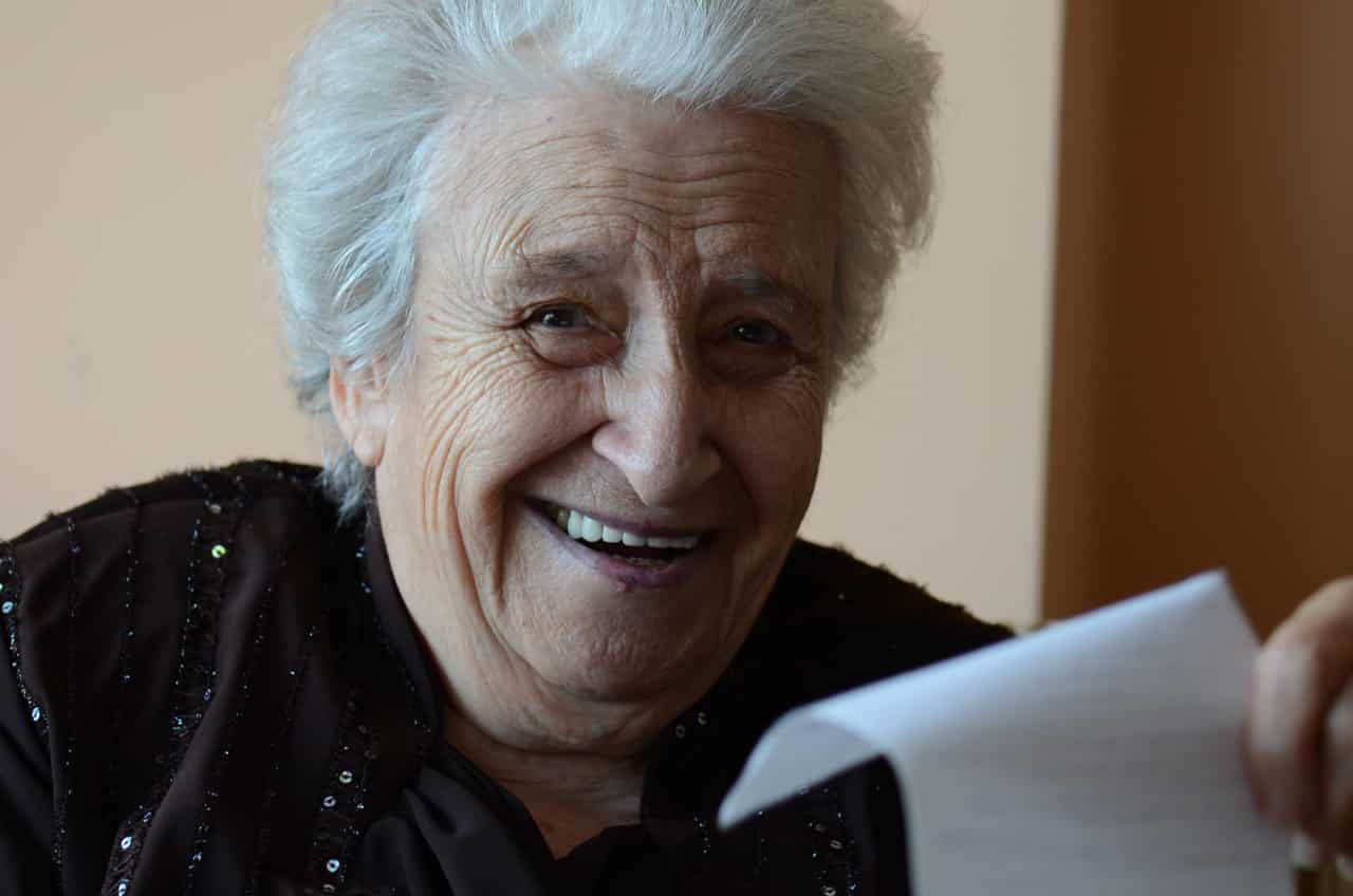 Eine alte lachende Dame mit einem Zettel